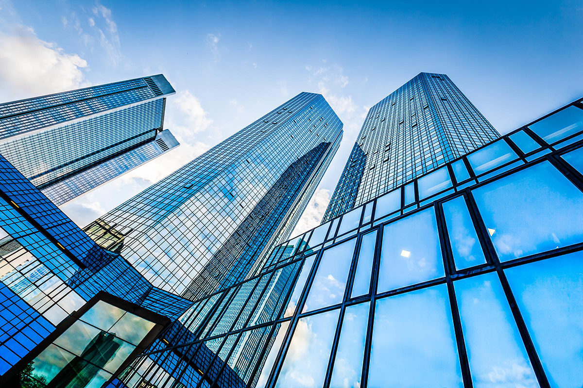 Bottom view of modern skyscrapers in business district against blue sky.